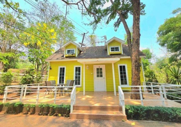 A small yellow house with stairs leading up to it