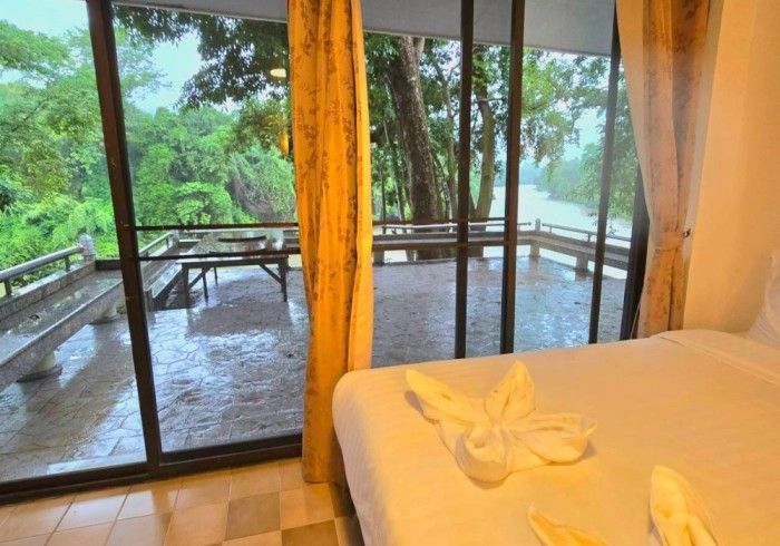 A bedroom with a bed and a sliding glass door leading to a balcony.
