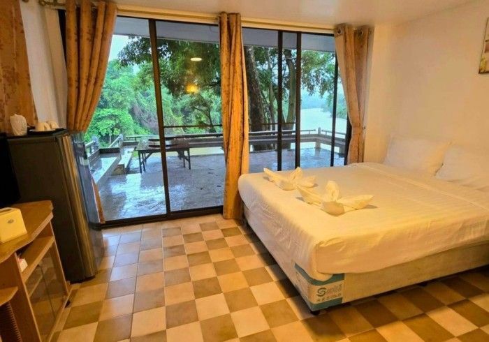 A hotel room with a large bed and a sliding glass door.