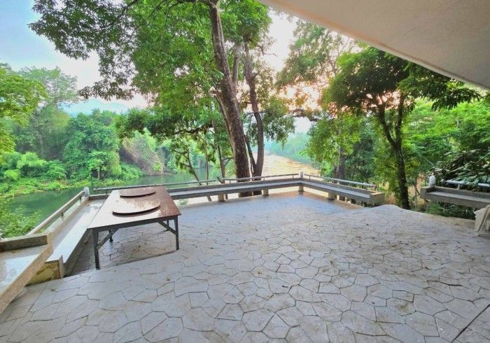 A patio with a view of a river and trees