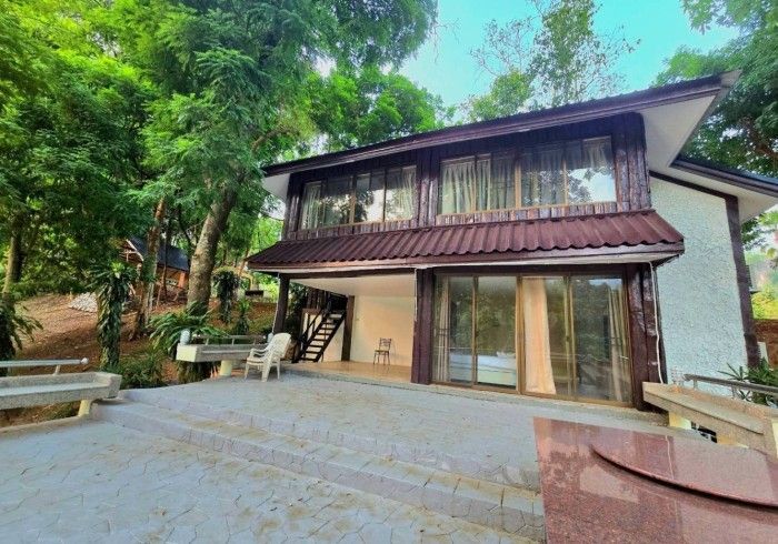 A large house with a lot of windows is surrounded by trees.