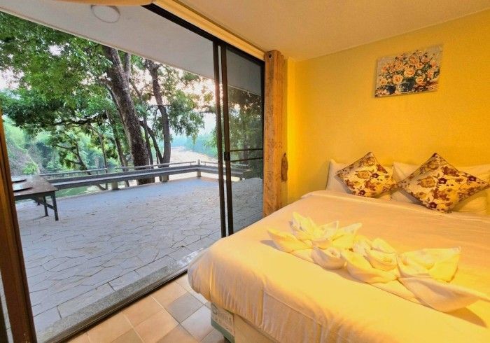 A bedroom with a bed and a sliding glass door leading to a balcony.