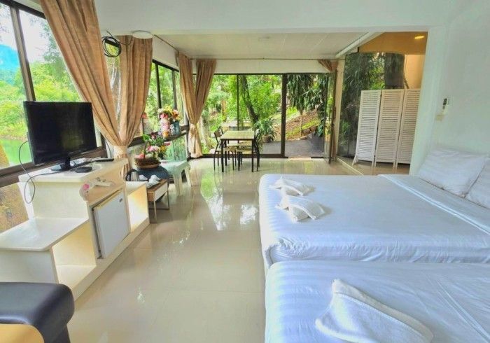 A hotel room with two beds , a television , a table and chairs.