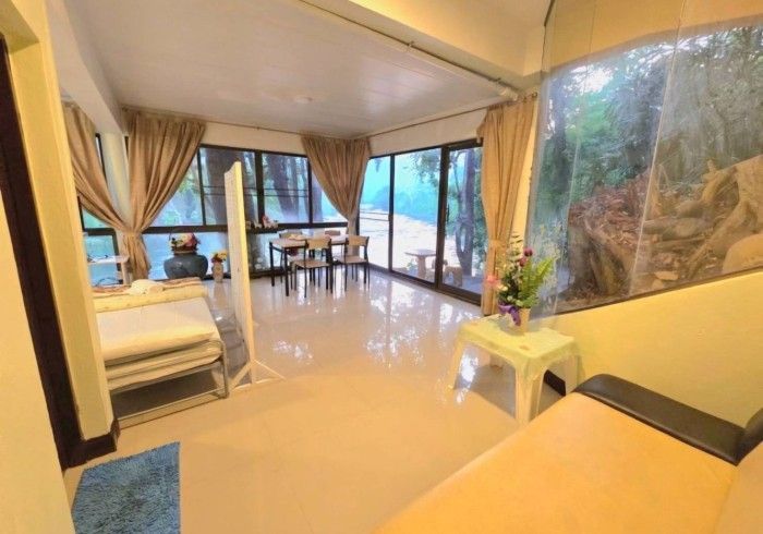 A living room with a couch , table , chairs and a large window.