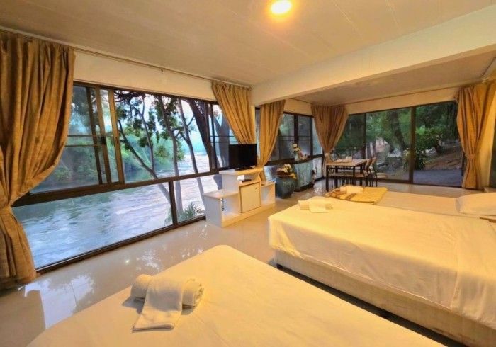 A hotel room with two beds , a table and a television.