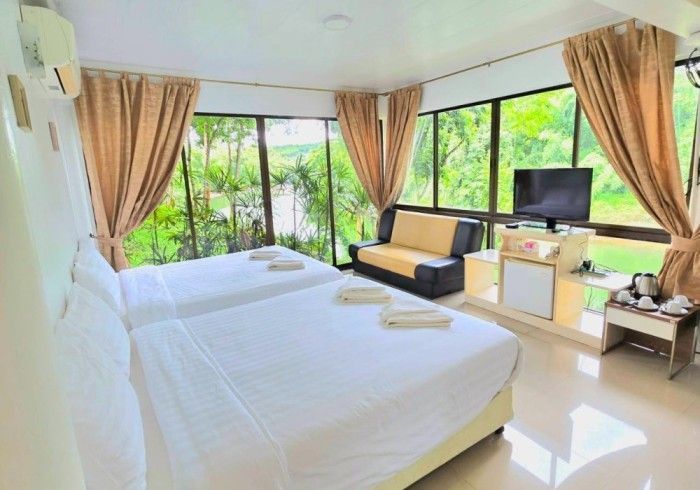 A hotel room with two beds a couch and a television