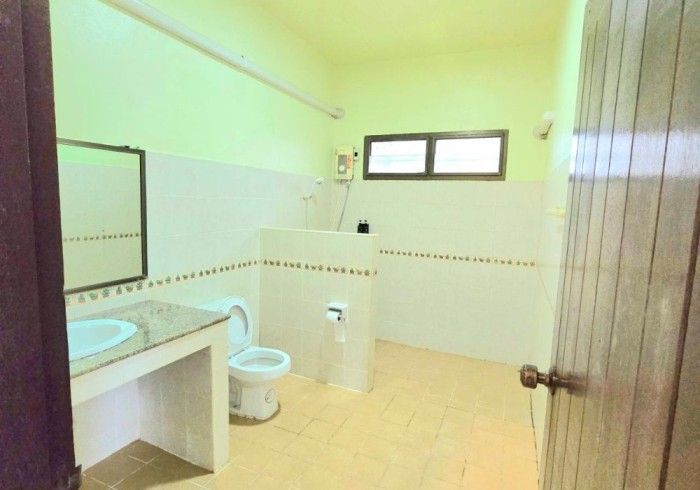 A bathroom with a toilet a sink and a mirror