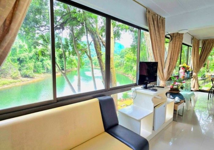 A living room with a couch and a television with a view of a river.