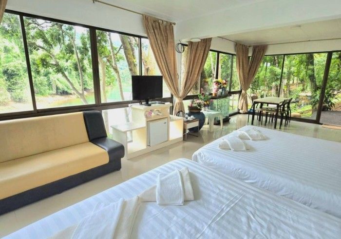 A hotel room with two beds , a couch , and a television.