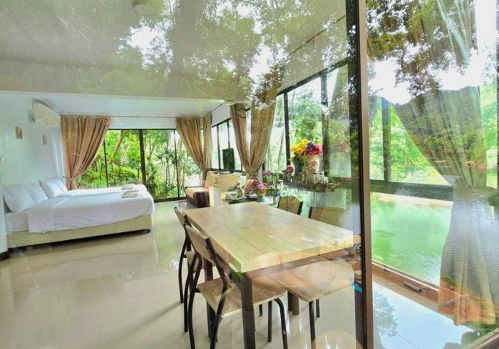 A living room with a table and chairs and a large window.