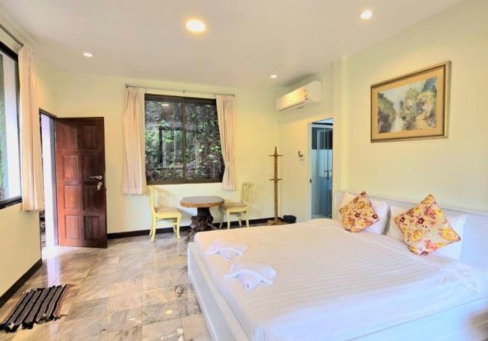 A hotel room with a large bed , table and chairs.