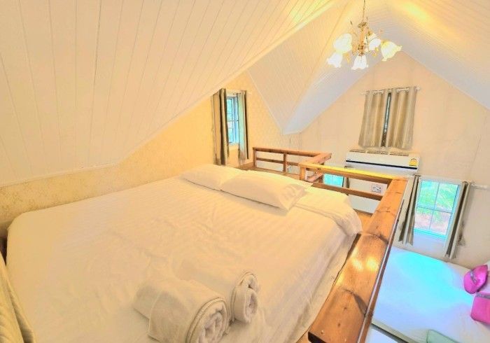A bedroom with a bed and a balcony in the attic.