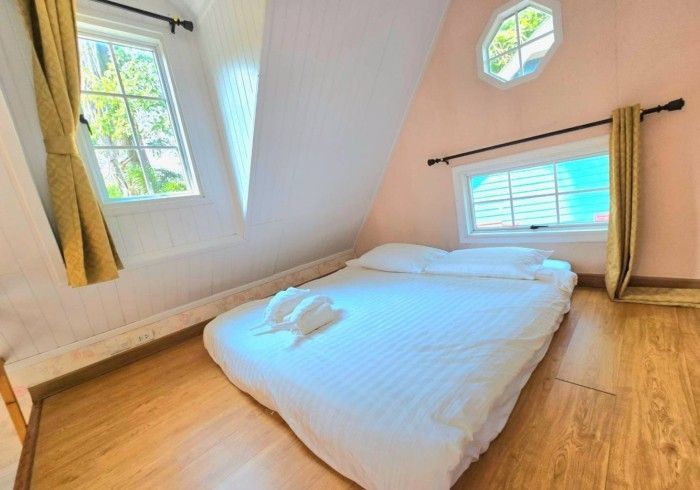 There is a bed in the middle of the room with a window.
