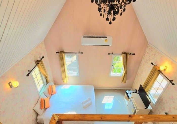 A bedroom with a bed and a chandelier hanging from the ceiling