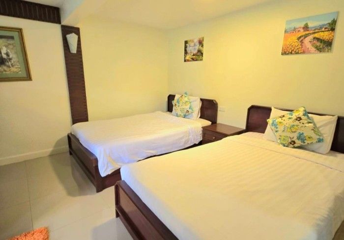 A hotel room with two beds and two paintings on the wall.