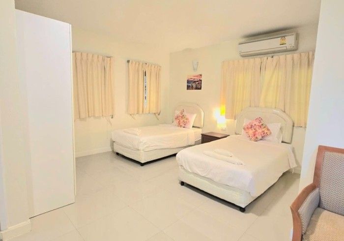 A hotel room with two beds and a chair.