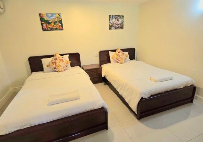 A hotel room with two beds and a clock on the wall.