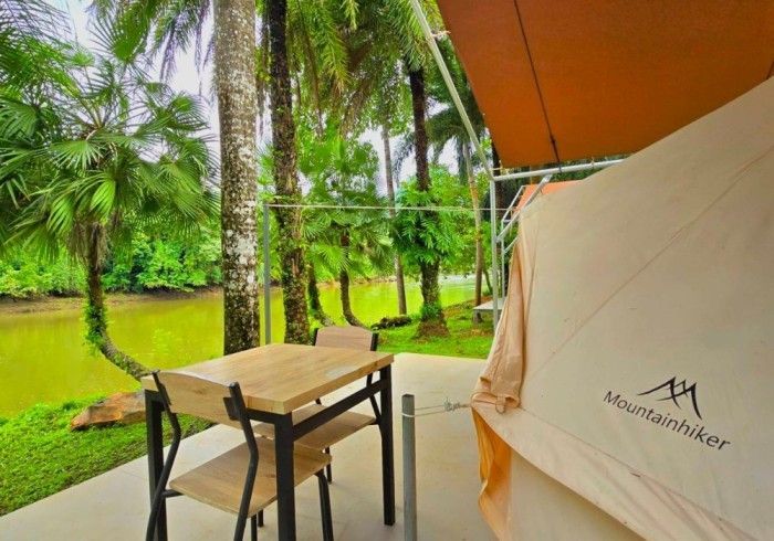There is a table and chairs outside of a tent.