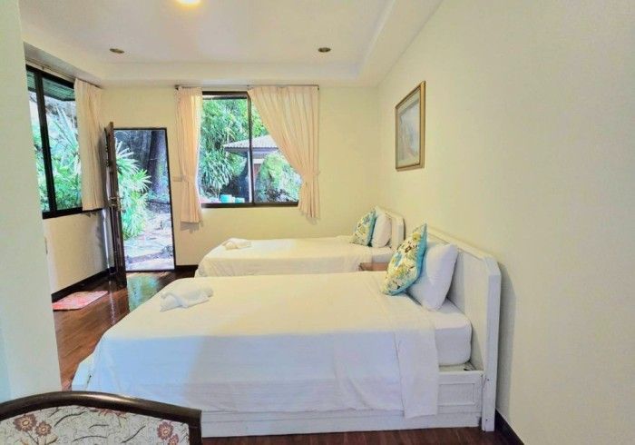 A hotel room with two beds and a chair.