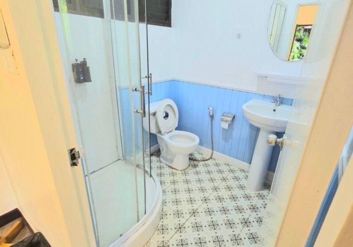 A bathroom with a toilet , sink and shower.