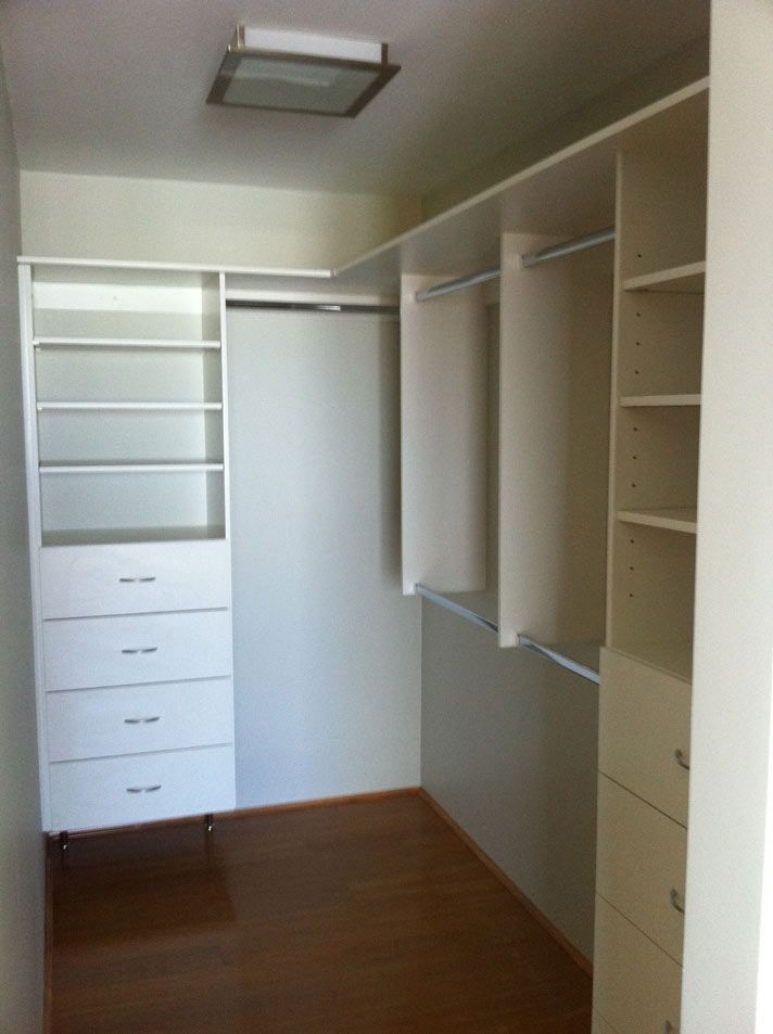 walk in wardrobe with white shelves and metal rods