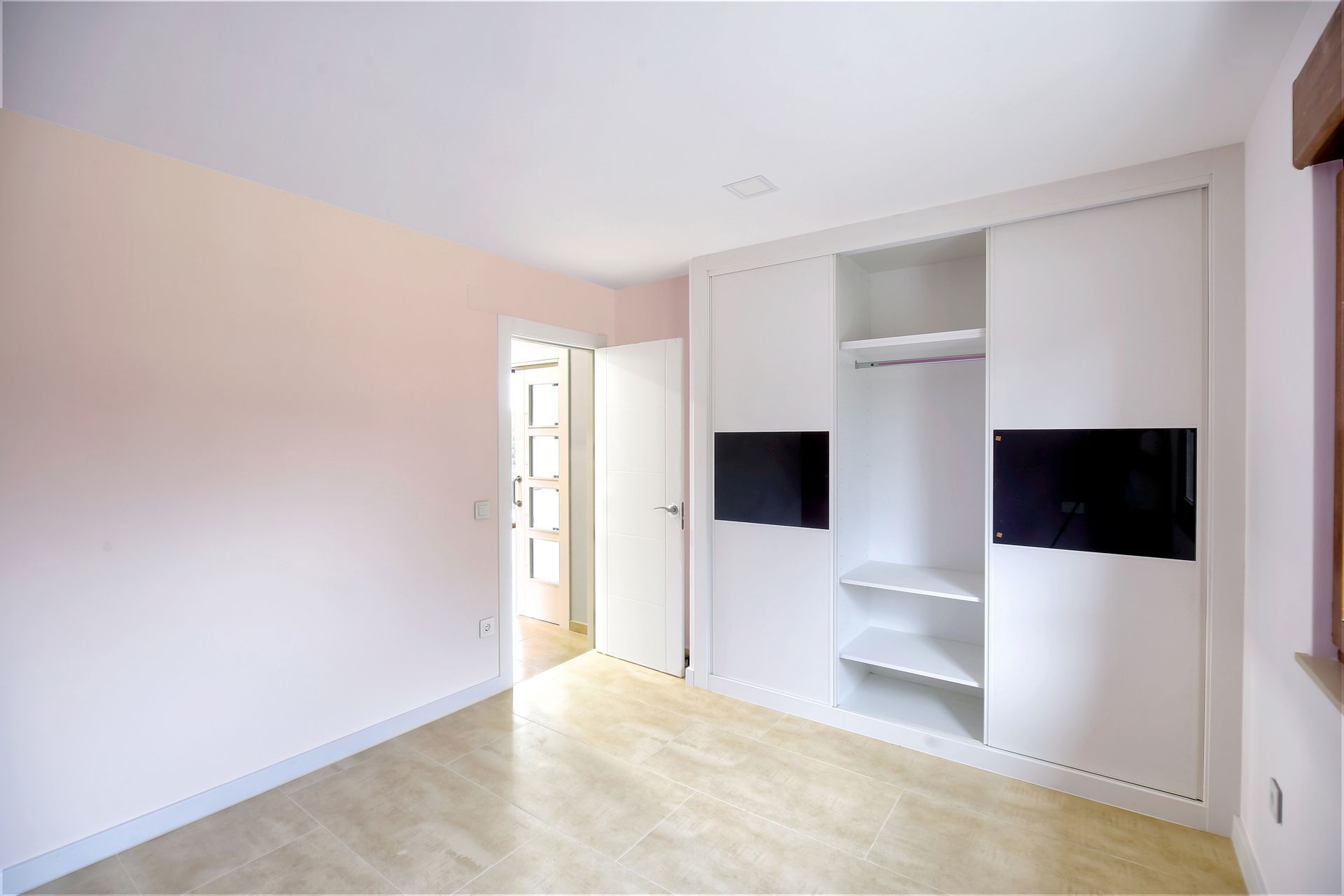 An empty room with a flat screen tv on the wall