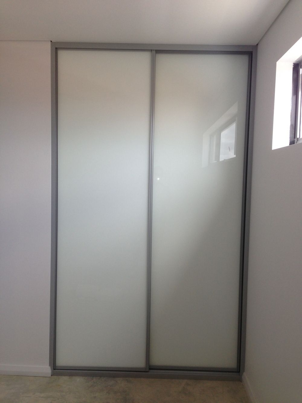 built in sliding wardrobe in white glass