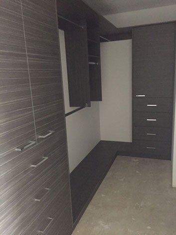 corner of walk in wardrobe with brown cupboards