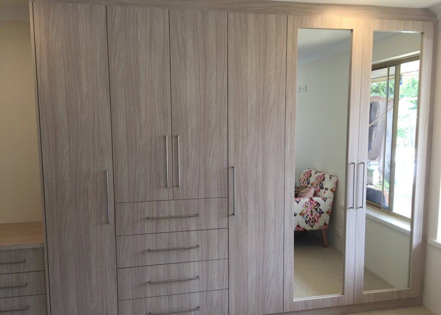 tan wood wardrobe with vertical mirrors