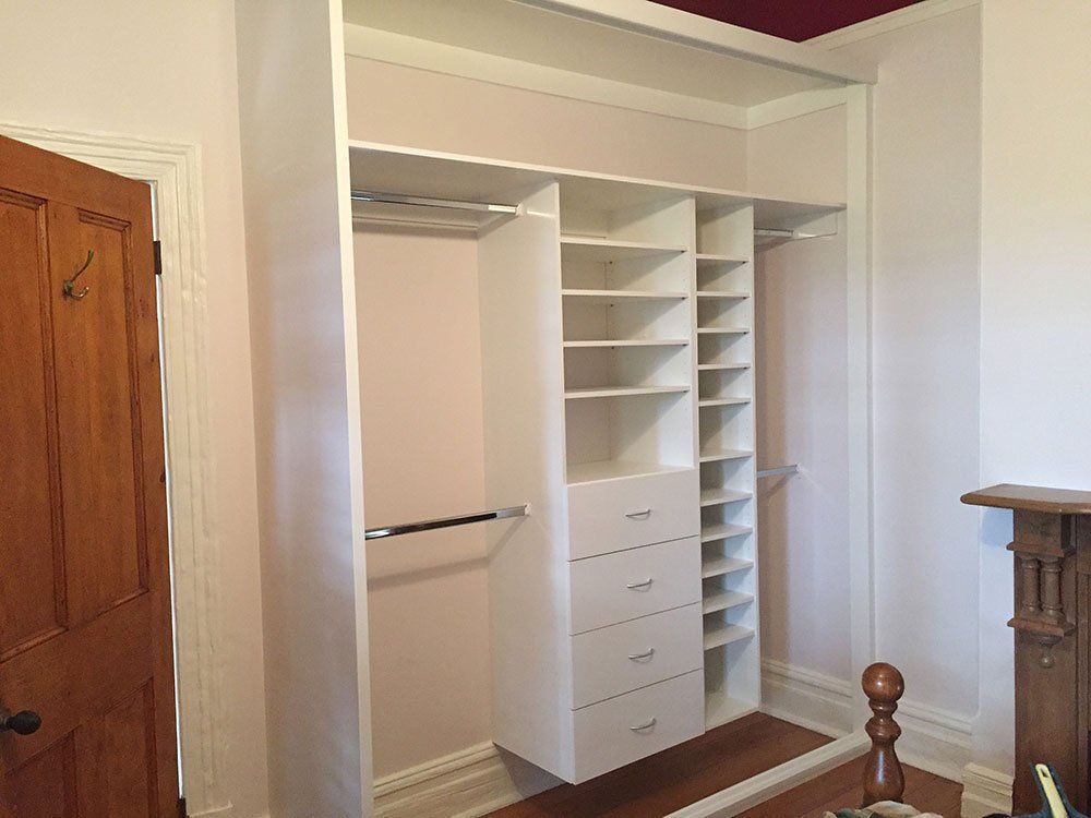 white closet with various shelves and drawers