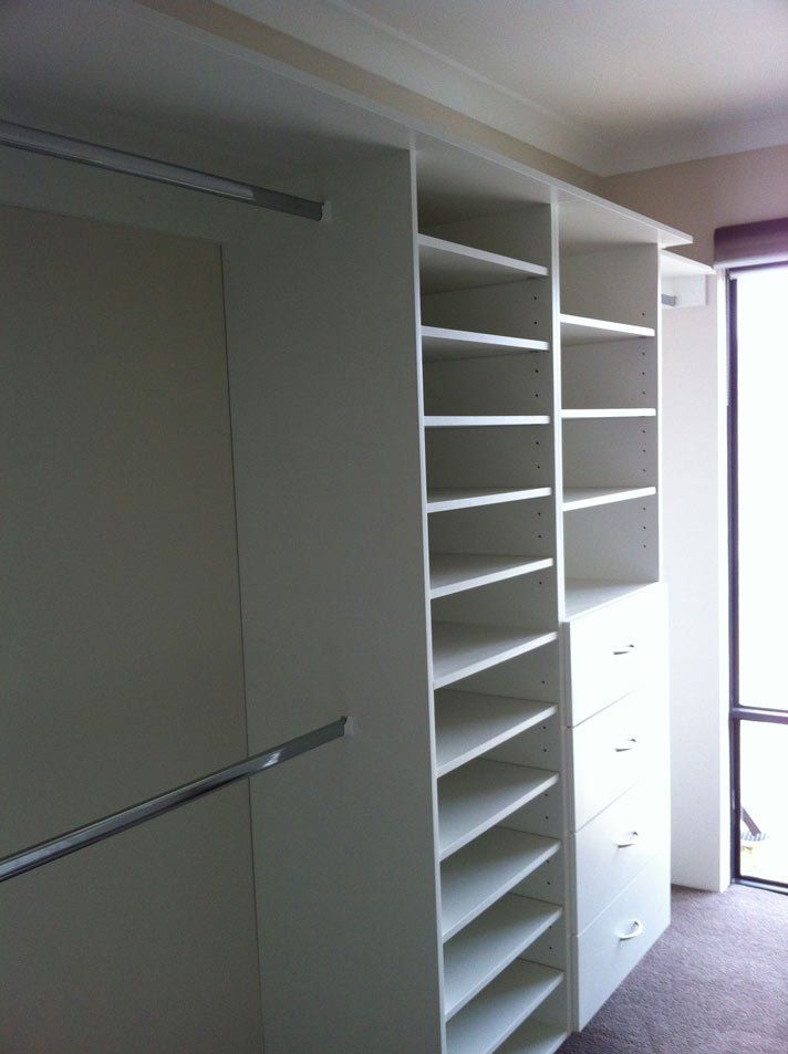 second view of walk in wardrobe with white shelves