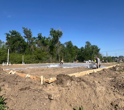 A group of construction workers are pouring concrete on a construction site.