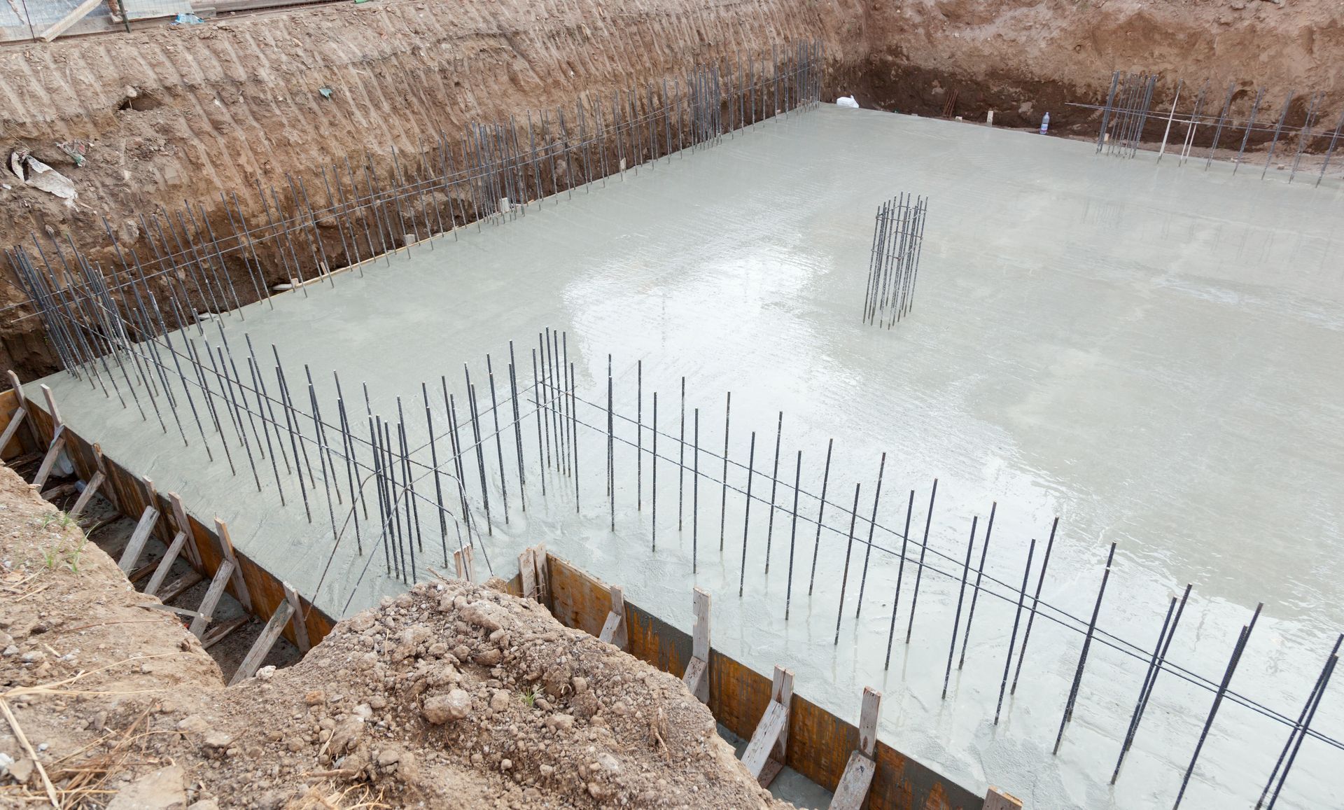 A large concrete pool is being built in a construction site.
