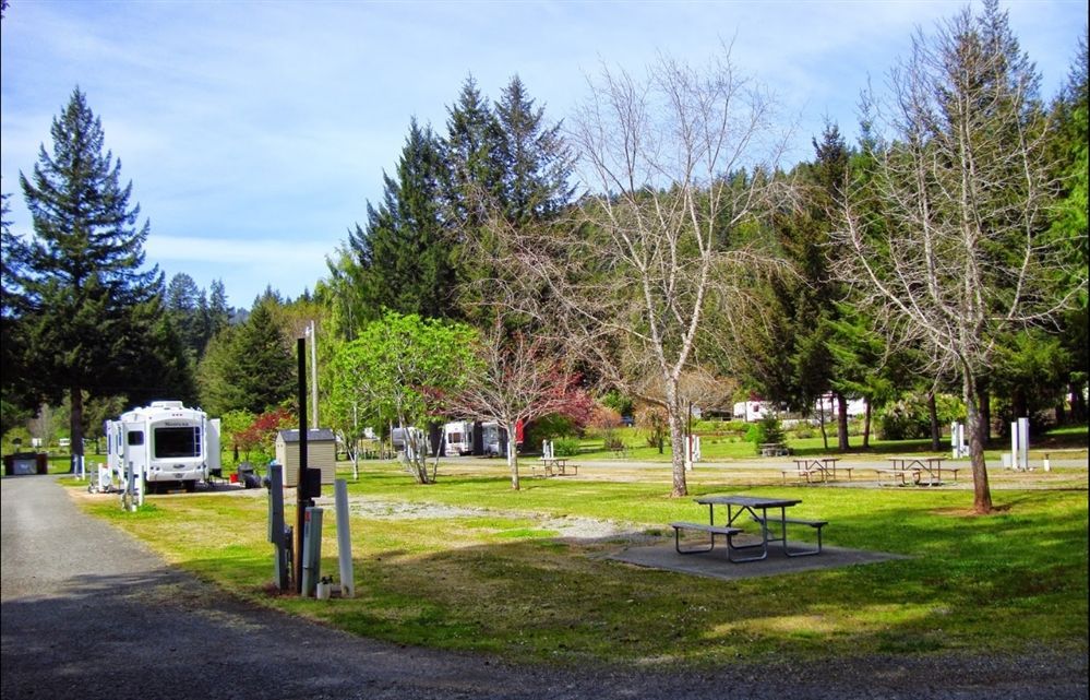 A rv parked in a grassy area with a picnic table