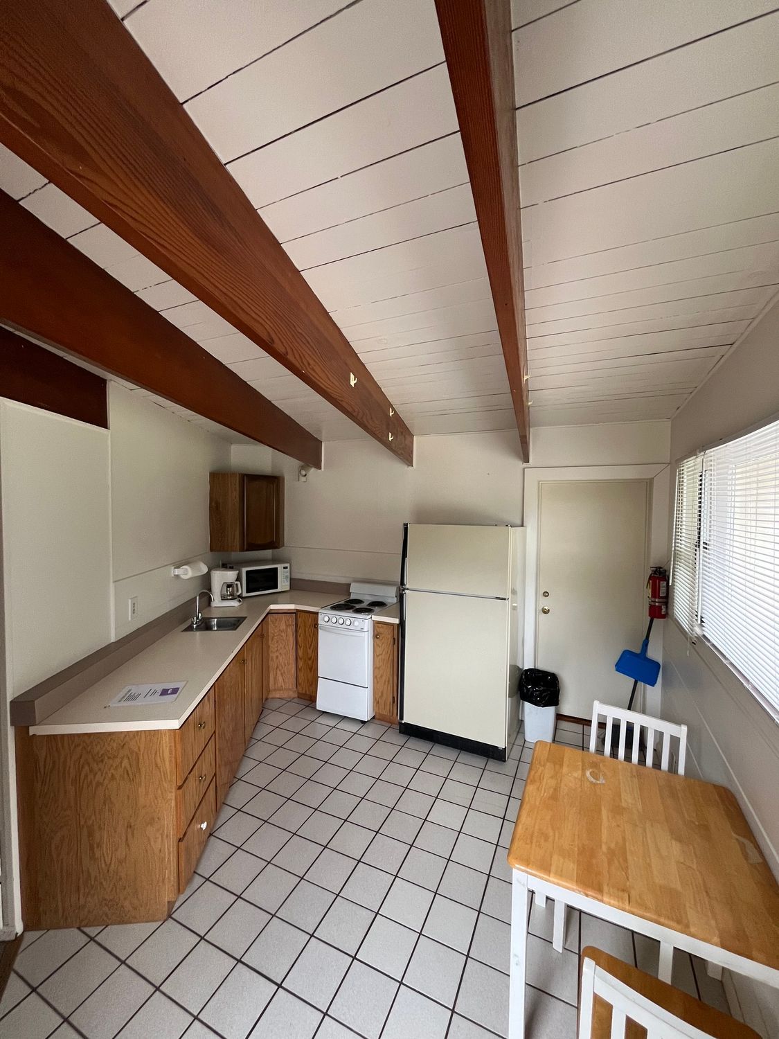 A kitchen with a table and chairs and a refrigerator