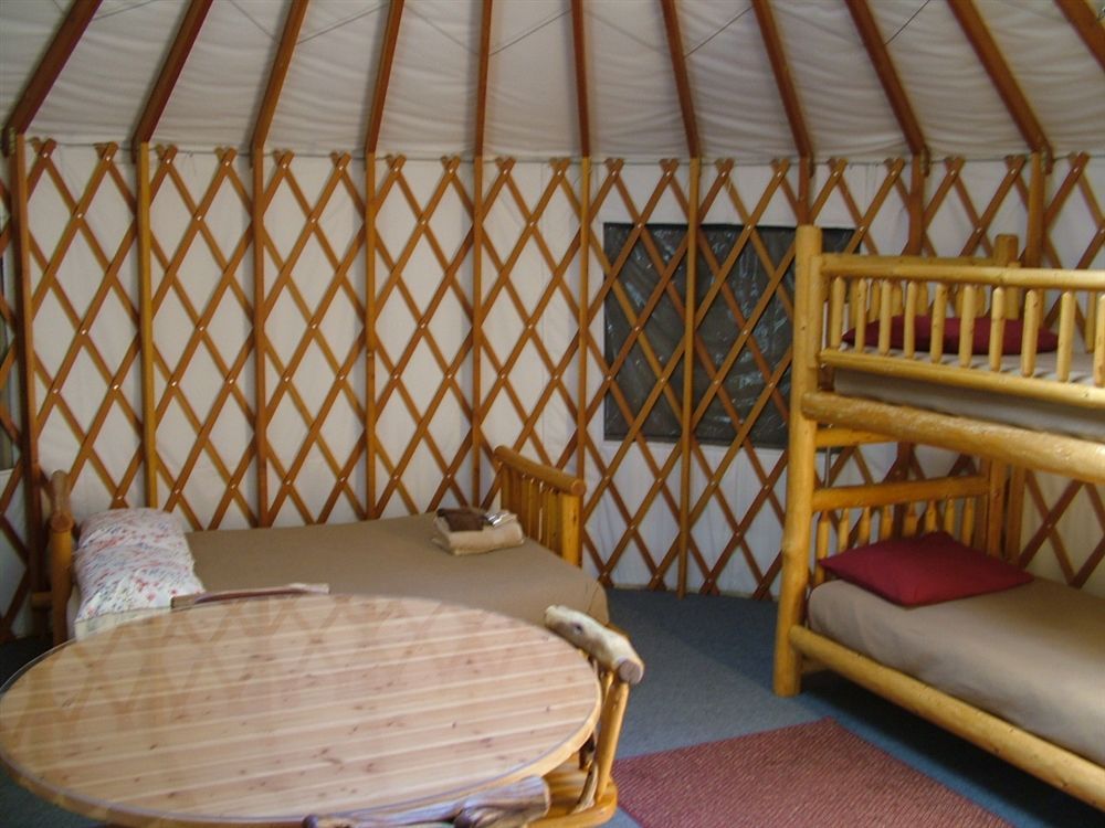 The inside of a yurt with bunk beds and a table