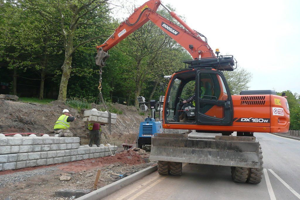 crane being used for a lava rock retaining wall