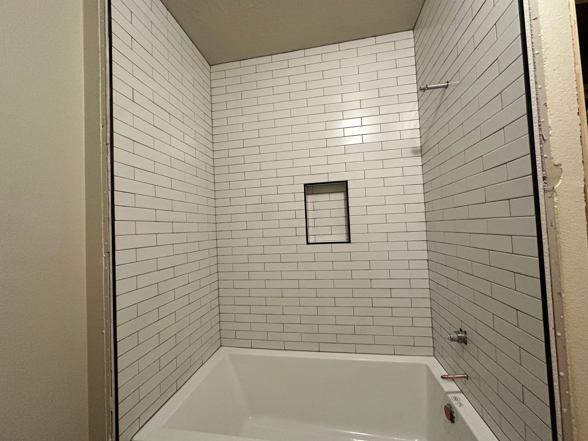 A bathroom with white brick walls and a bathtub