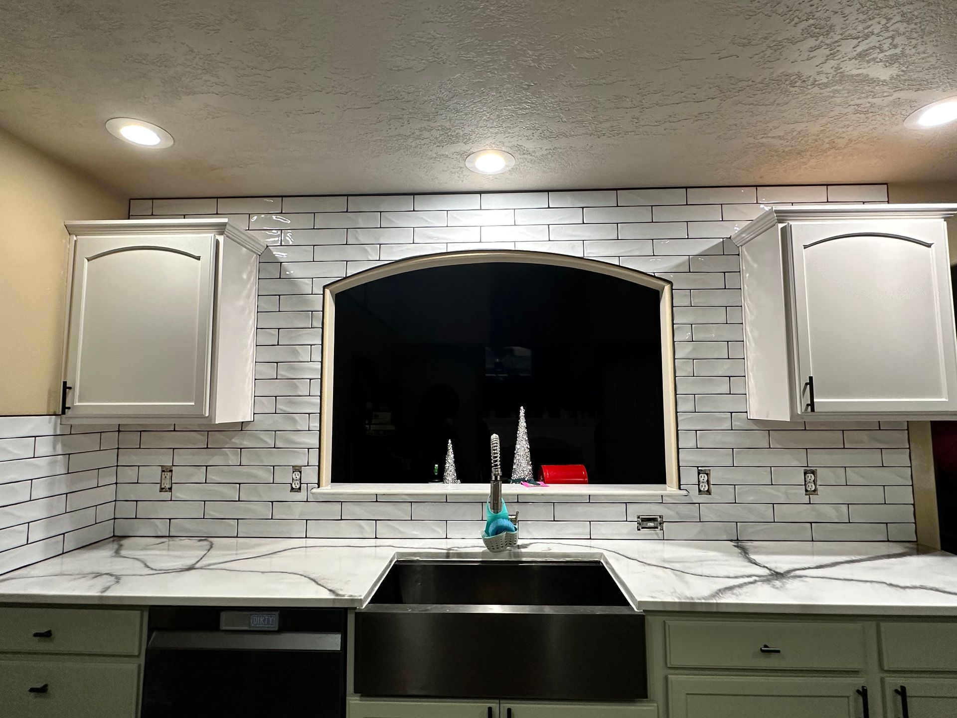 A kitchen with white cabinets and a stainless steel sink