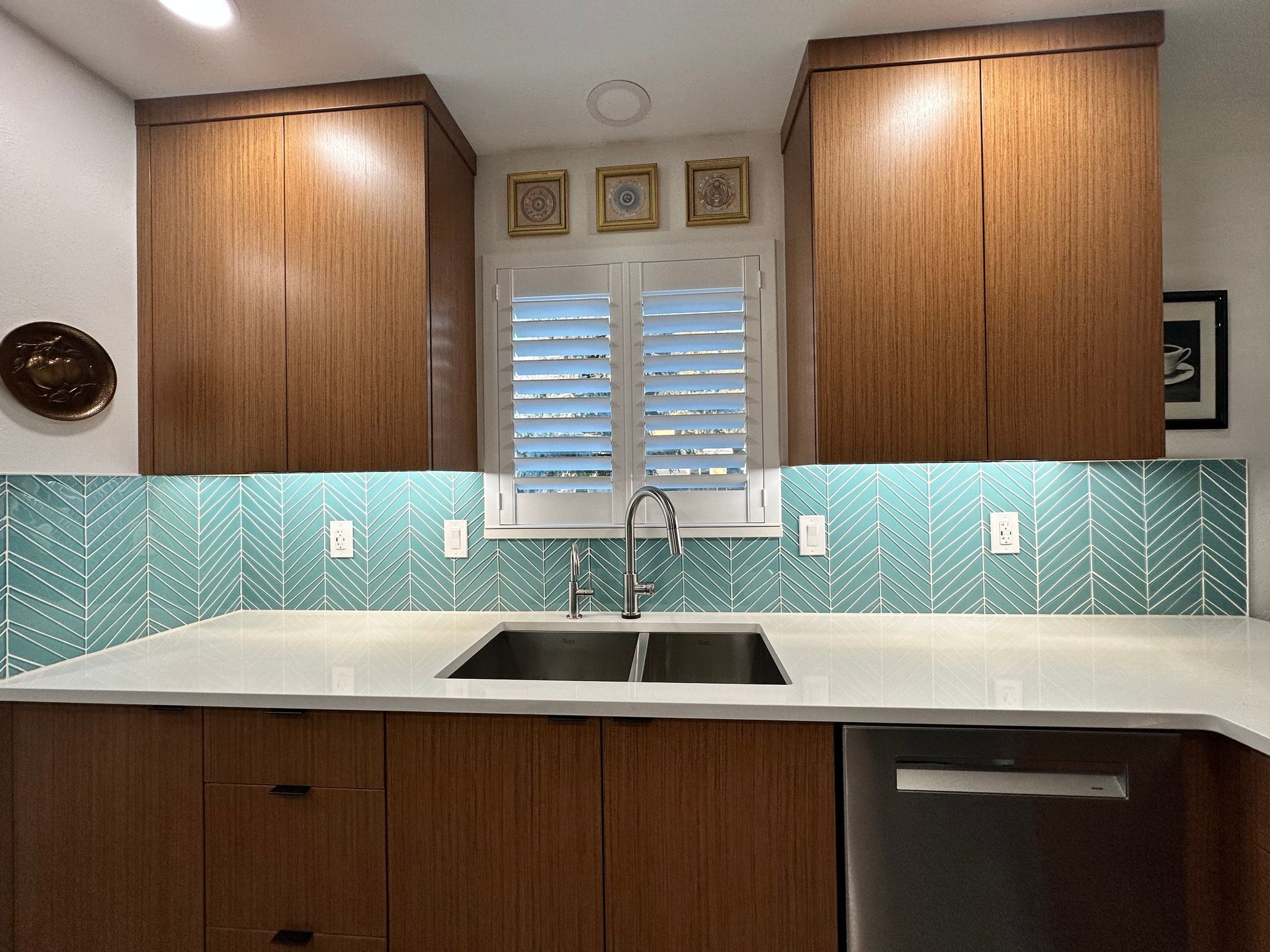 A kitchen with a sink and a window with shutters