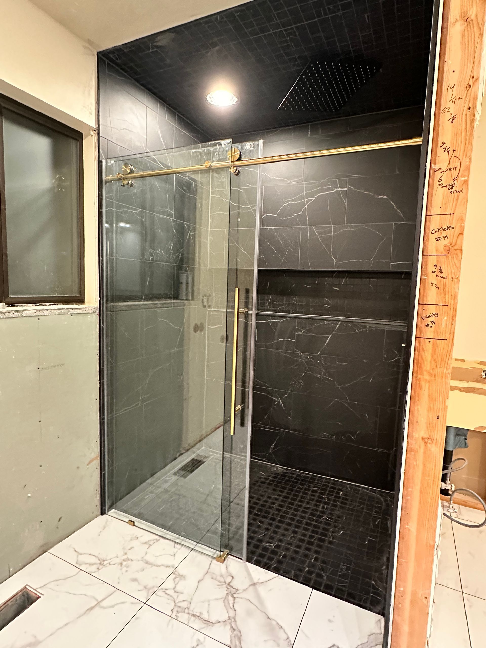 A bathroom with a sliding glass shower door.