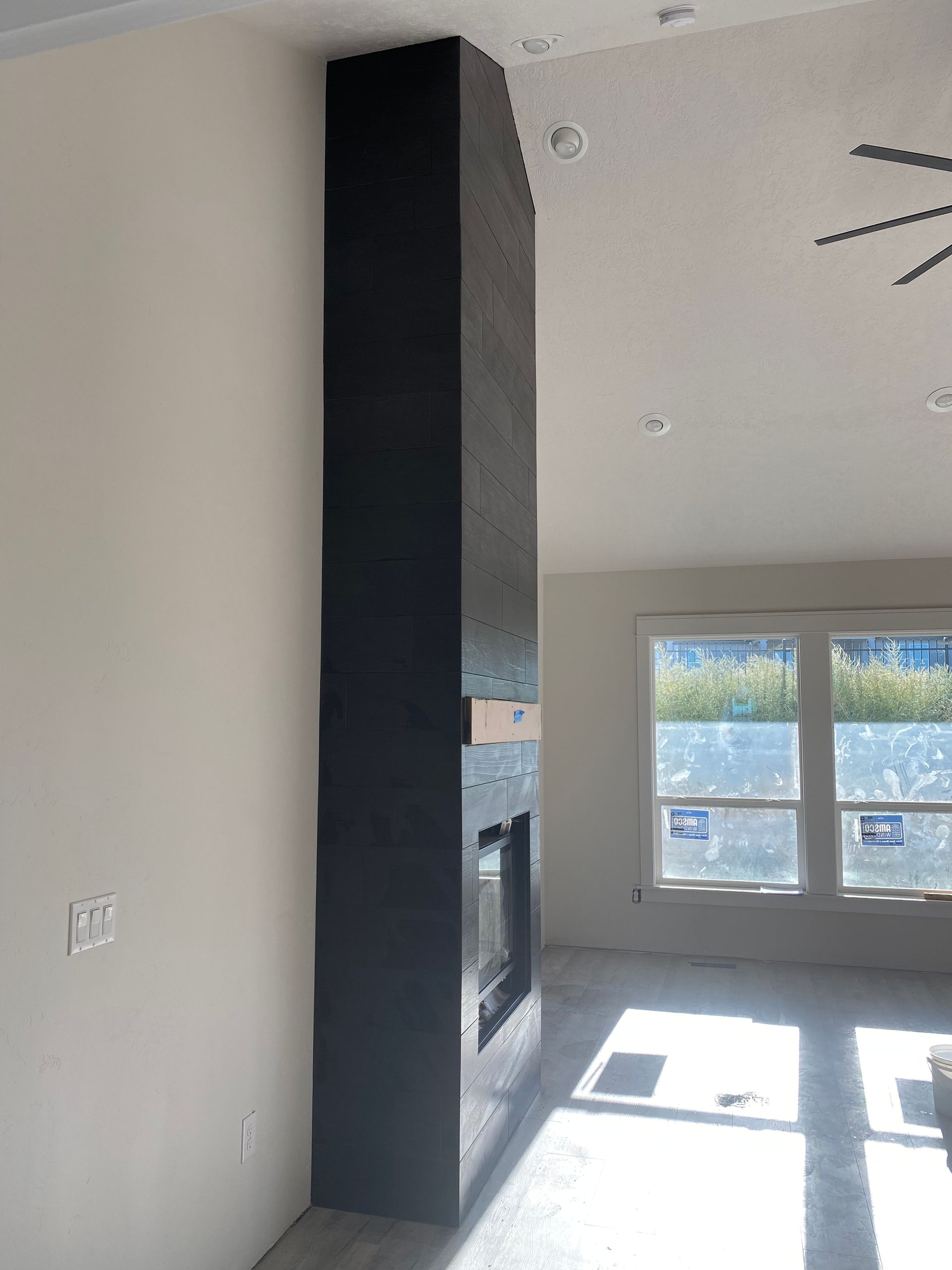 A living room with a fireplace and a ceiling fan