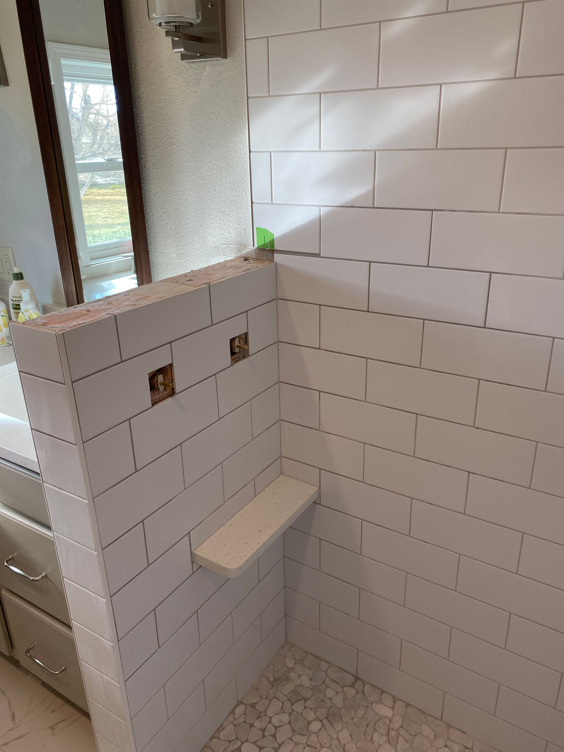 A bathroom with a walk in shower and a sink.