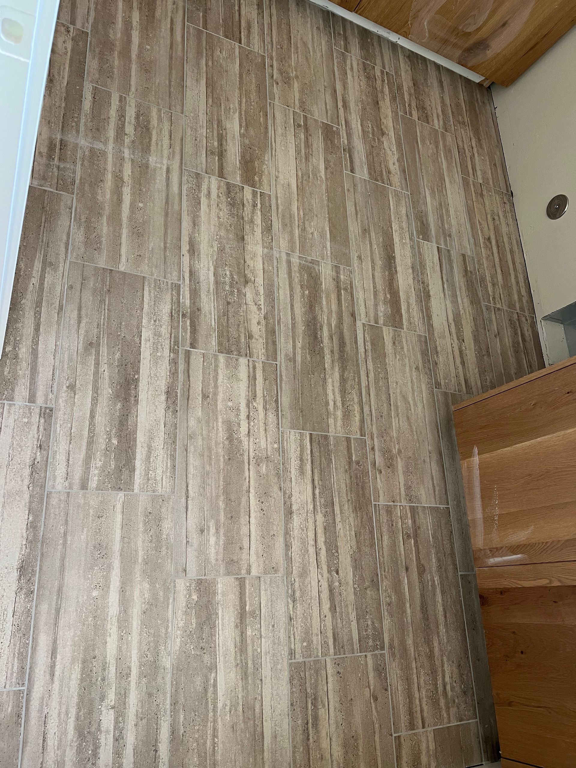 A bathroom with a wooden floor and a wooden cabinet.