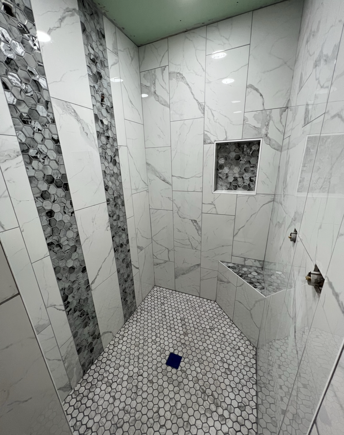 A bathroom with marble tiles and a walk in shower