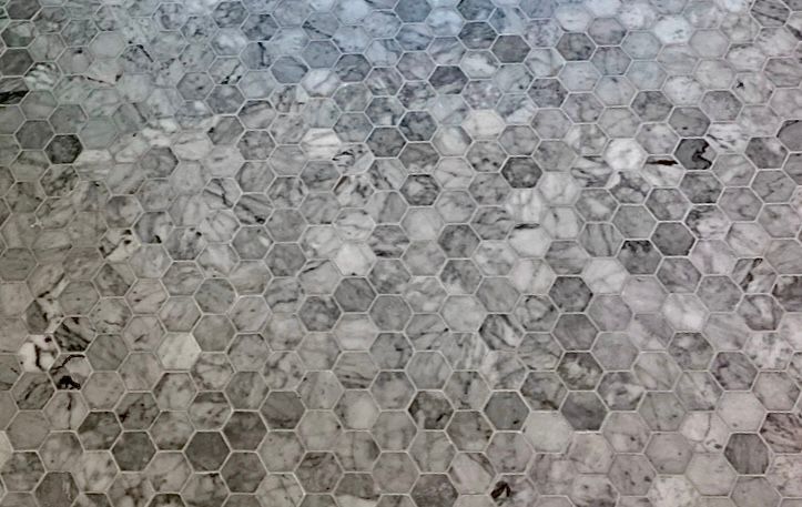 A close up of a tile floor with a honeycomb pattern.
