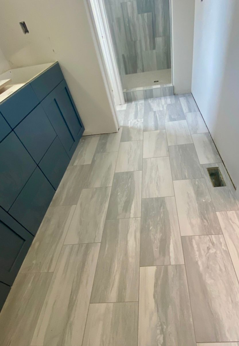 A bathroom with a tiled floor and blue cabinets.