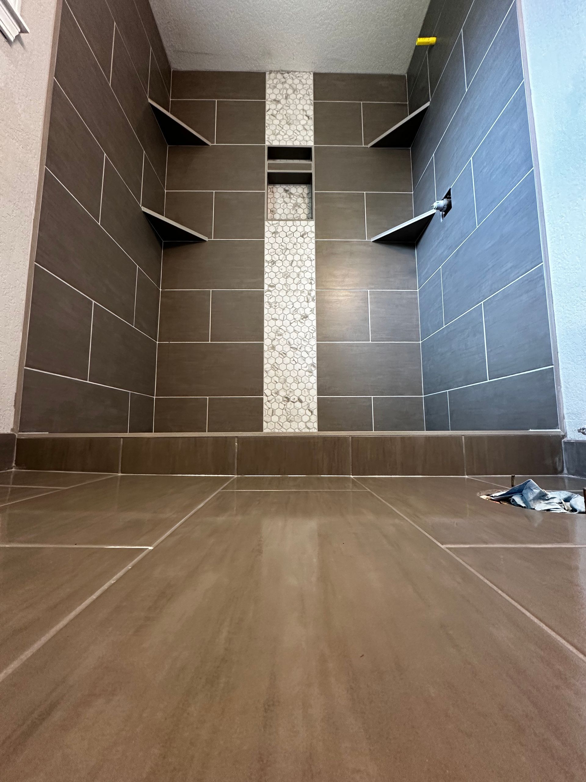 A bathroom with a tiled floor and a shower stall