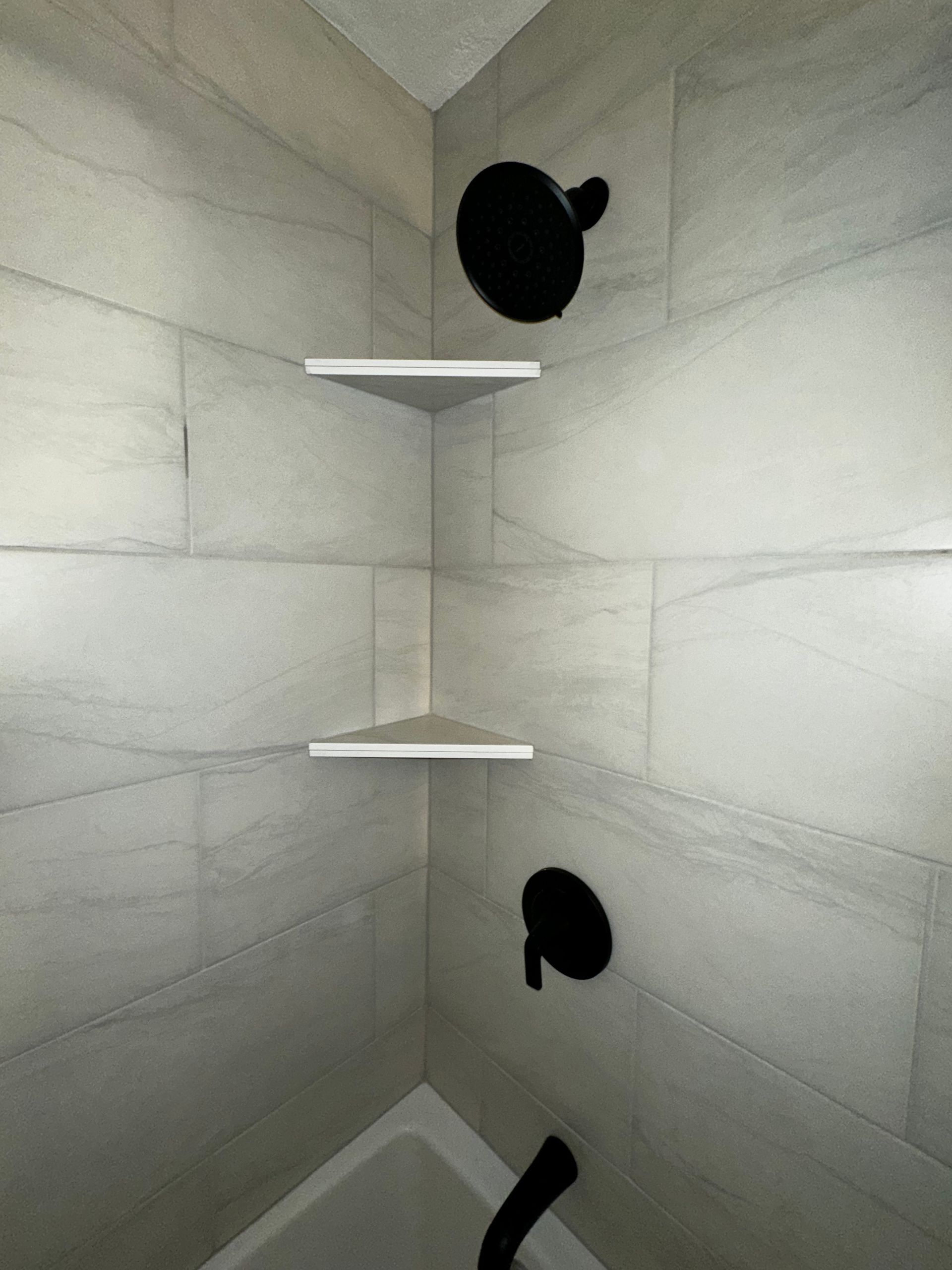 A bathroom with a tub , shower , and shelves.