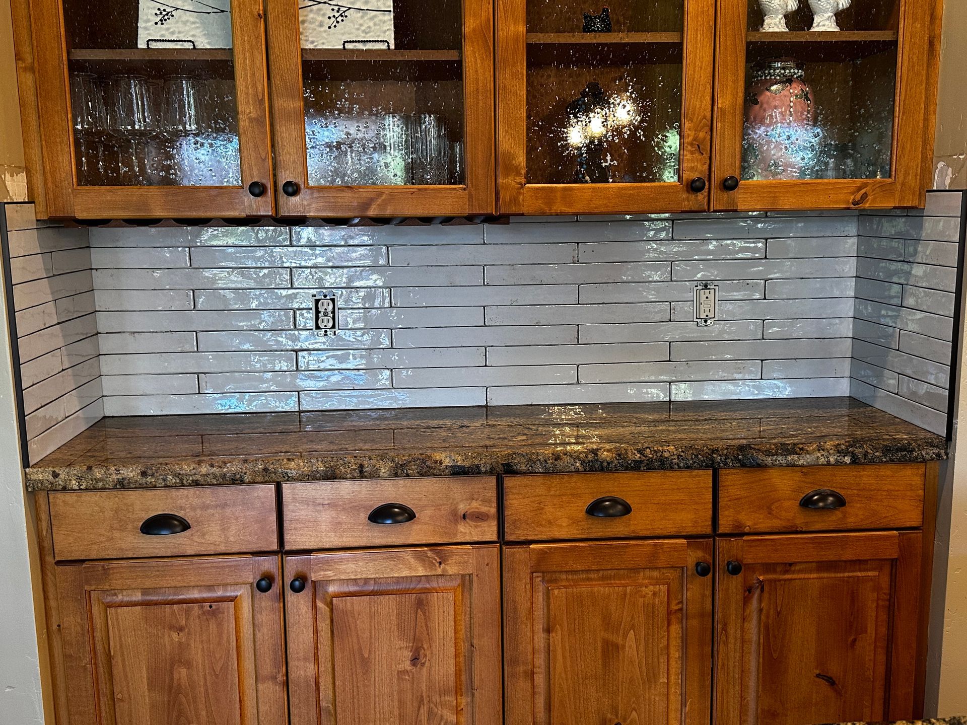 A kitchen with wooden cabinets and a granite counter top.